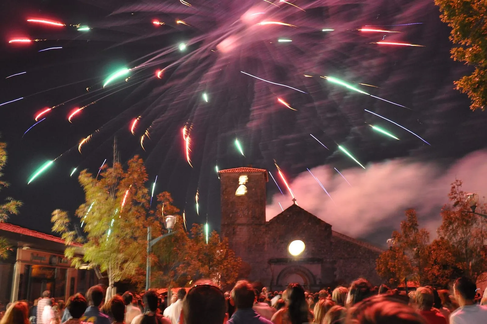 Un feu d'artifice éclaire le ciel au-dessus d'un village
